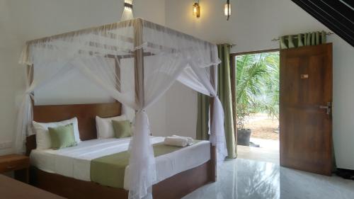 a bedroom with a bed with a canopy at Green Luxe in Dambulla