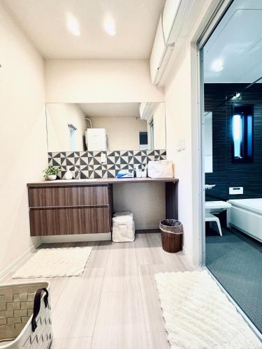 a bathroom with a tub and a sink at Akikawa Koshi 3 プレミアム鉄骨 一棟貸切ヴィラ in Yuge