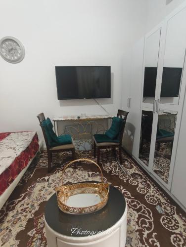 a living room with a tv and chairs and a table at studio in Abu Dhabi