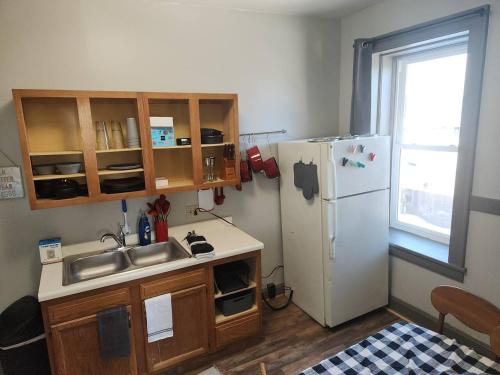a small kitchen with a sink and a refrigerator at K5 2nd Floor Studio Near MTU, Keweenaw, Great Rates