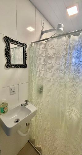 a bathroom with a shower curtain and a sink at Loft 967 in Itajaí