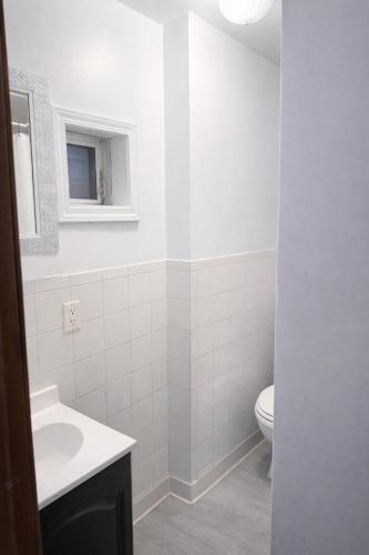 a white bathroom with a toilet and a sink at Location! Location! 2bd 1bth spacious apartment! in Chicago