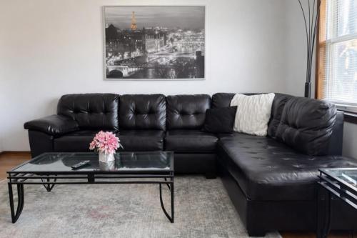 a black leather couch in a living room with a coffee table at Location! Location! 2bd 1bth spacious apartment! in Chicago