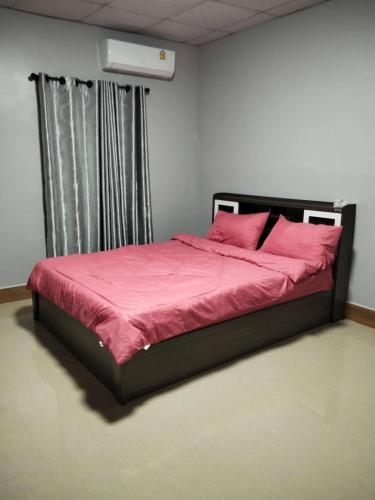a bedroom with a bed with pink sheets and a window at Crowd free own pace and space in Rayong in Ban Chak Khamin