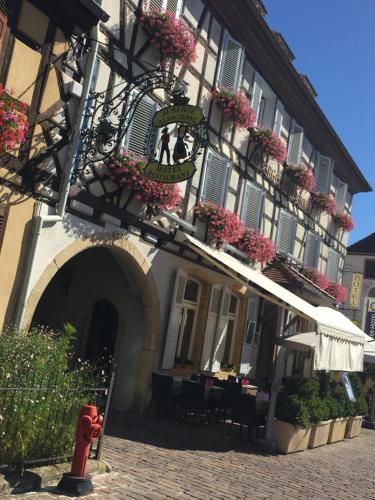 a building with flower boxes on the side of it at Hôtel L'Auberge Alsacienne in Eguisheim