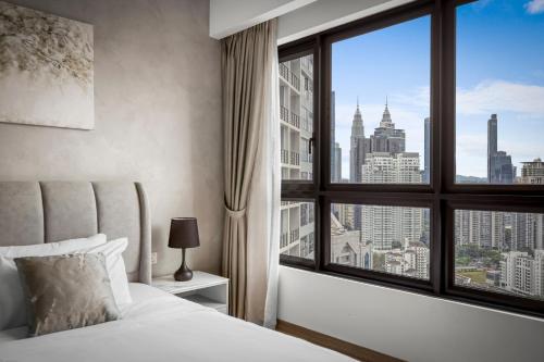 a bedroom with a large window with a city view at Cavera Bukit Bintang in Kuala Lumpur