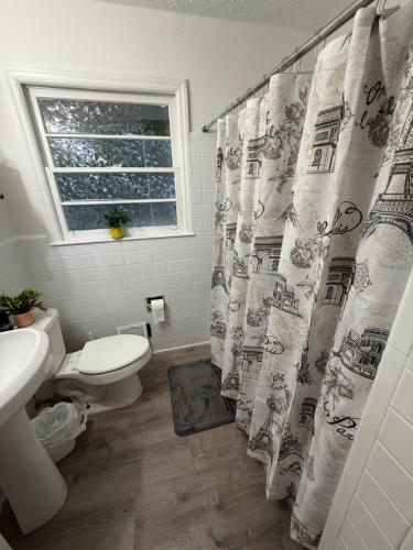 a bathroom with a toilet and a shower curtain at Crema queen in Decatur