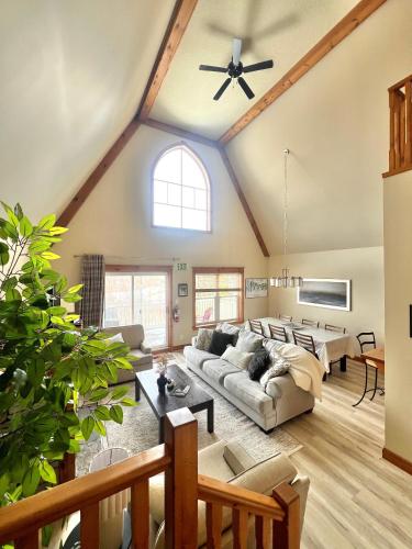 a living room with a vaulted ceiling with a ceiling fan at The Blue Escape Blue Mountain Chalet in Blue Mountains