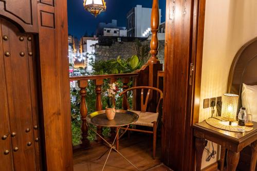 a small table and chair in a room with a window at بوتيك خان عطره in Medina