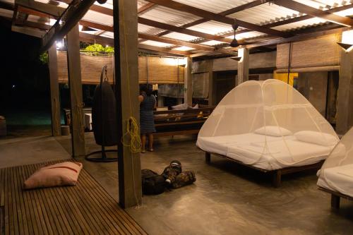 a room with two beds and a woman standing in the background at Panthera Lodge Yala in Kirinda