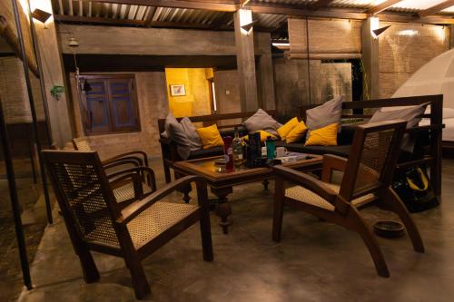 a living room with a couch and a table and chairs at Panthera Lodge Yala in Kirinda