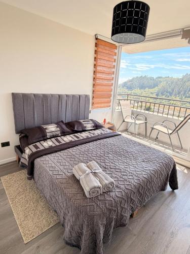 a bedroom with a bed and a large window at Hermoso departamento nuevo en Concepción 3 in Concepción