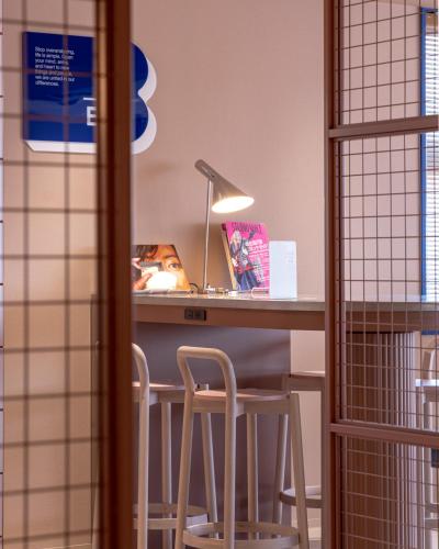 a desk with two stools at a table with a lamp at THE BASEMENT HOTEL OsakaHonmachi in Osaka