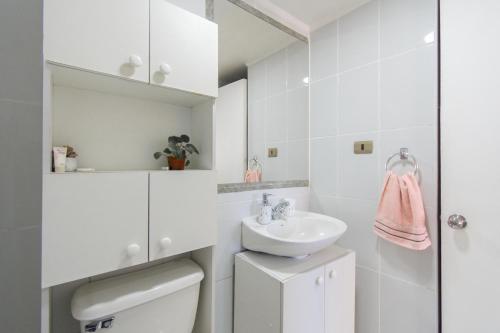 a white bathroom with a sink and a toilet at Alta vista Concepción in Concepción