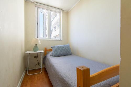 a small bedroom with a bed and a window at Alta vista Concepción in Concepción