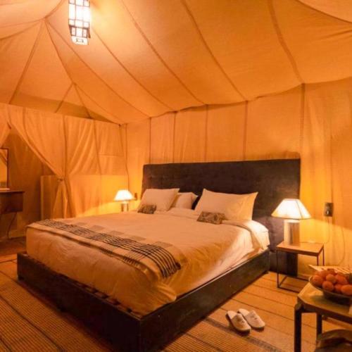 a bedroom with a bed in a tent at Merzouga Traditional Camp in Merzouga
