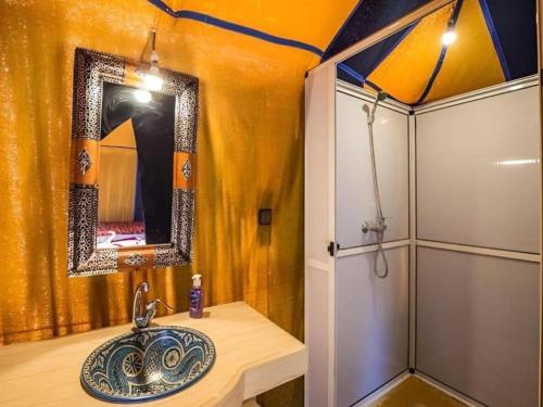 a bathroom with a sink and a shower at Merzouga Traditional Camp in Merzouga