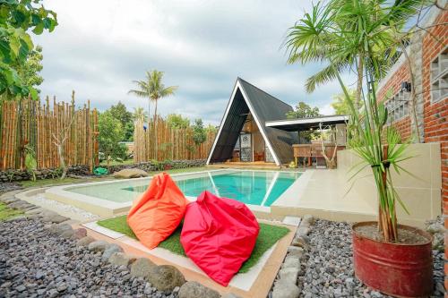 two colorful pillows sitting next to a swimming pool at Villa Kebon Paman in Balong