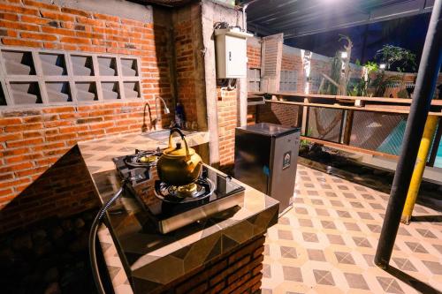 a kitchen with a tea kettle on a stove at Villa Kebon Paman in Balong