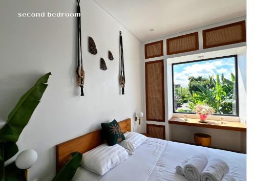 a bedroom with a bed and a window at Surya Palm Villa in Tumbak Bayuh