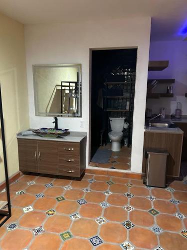 a bathroom with a toilet and a dresser with a mirror at AG Dusty Luxe Suite #3 in San Miguel de Allende