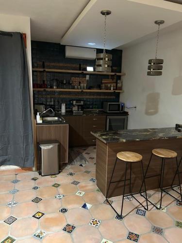 a kitchen with a counter and two stools at AG Dusty Luxe Suite #3 in San Miguel de Allende