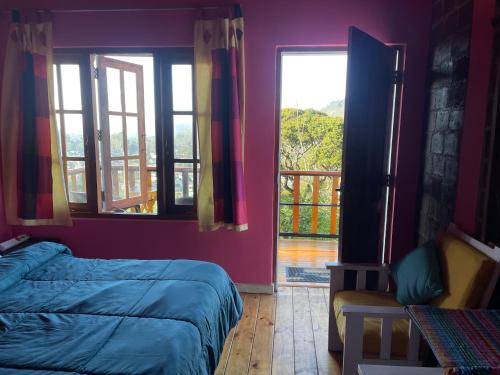 a bedroom with two beds and a balcony with windows at Sincere Wilderness Home stay in Nuwara Eliya