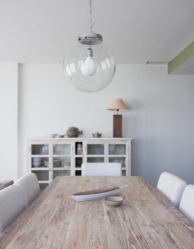 - une salle à manger avec une table en bois et un éclairage dans l'établissement Port Rive Gauche Roseliere, à Marseillan