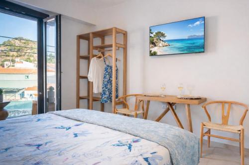a bedroom with a bed and a desk and a table at Eressian Lodgings - Skala Eressos in Skala Eresou