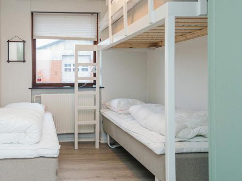 a bedroom with two bunk beds and a window at 4 star holiday home in Allingåbro in Allingåbro
