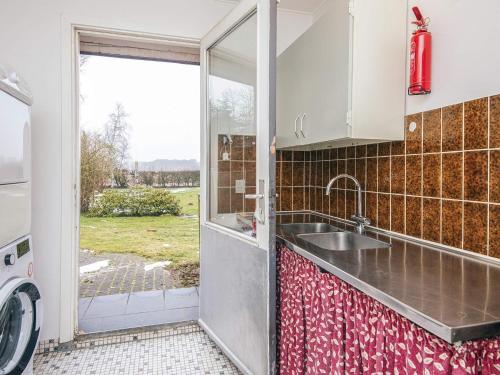 a kitchen with a sink and a sliding glass door at 4 star holiday home in Allingåbro in Allingåbro