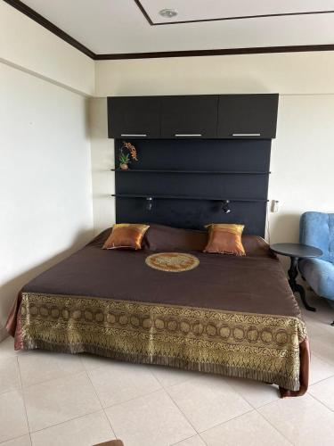 a bedroom with a large bed with a black headboard at Home at the Gulf of Thailand 1 in Ban Pak Khlong Phe