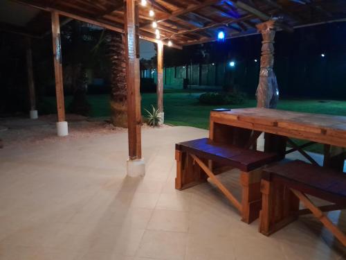 a wooden picnic table and bench under a pavilion at night at Casa en Xochimilco in Mexico City