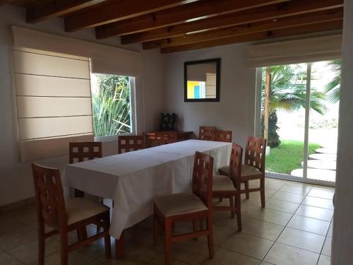 a dining room with a white table and chairs at Casa en Xochimilco in Mexico City