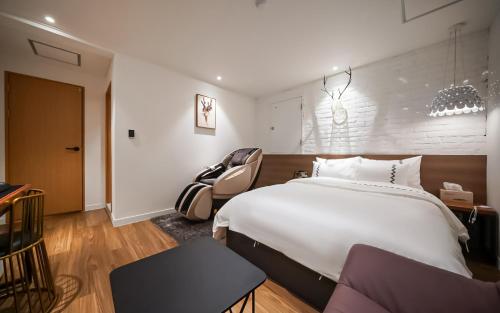 a bedroom with a large white bed and a chair at MARI hotel in Incheon