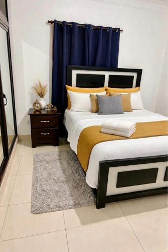 a bedroom with a large bed with blue curtains at Brisas de las Montañas in Jarabacoa