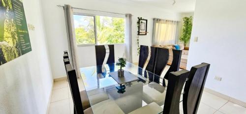 a dining room with a glass table and chairs at Brisas de las Montañas in Jarabacoa