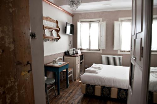 フィレンツェにあるRomantic Nest Florence Apartmentのベッドルーム1室(ベッド1台、デスク、テーブル付)