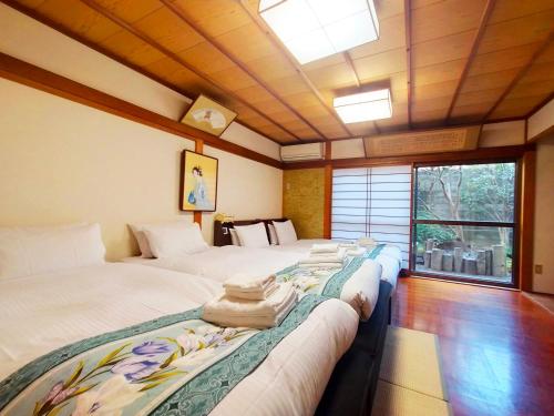 a room with two beds with towels on them at Yuririan in Kyoto