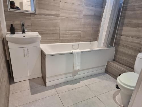 a bathroom with a tub and a sink and a toilet at Away Home in London