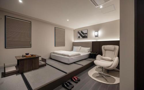 a bedroom with a bed and a desk and a chair at 아늑료칸 동대구역점 in Daegu