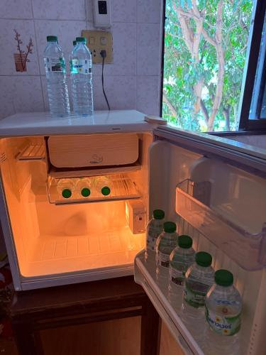 an open refrigerator with bottles of water in it at Lawans Hostel in Pattaya South
