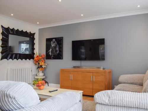 a living room with a couch and a tv at Bramble Cottage in Leven