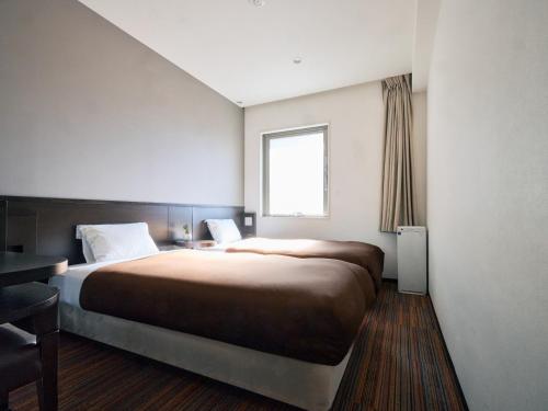 a bedroom with a large bed and a window at Urbain Tokyo Ueno Kitasenju in Tokyo