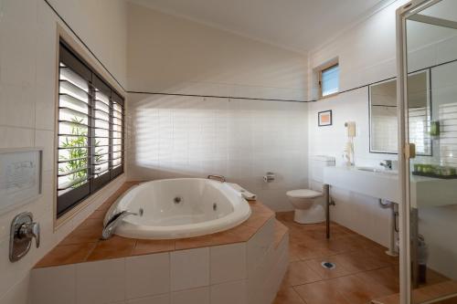 a white bathroom with a tub and a toilet at Eagle Heights Mountain Resort in Eagle Heights