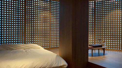 a bedroom with a bed in front of a wall of windows at Myeongwolga Poolvilla in Busan