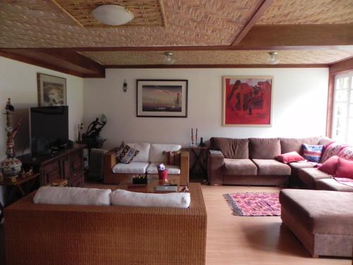 a living room with a couch and a tv at Casa do Fachoalto in Petrópolis