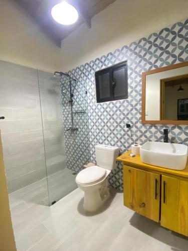 a bathroom with a toilet and a sink and a shower at Villa Campo Verde in Jarabacoa