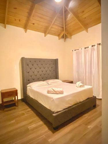 a large bed in a room with a wooden floor at Villa Campo Verde in Jarabacoa