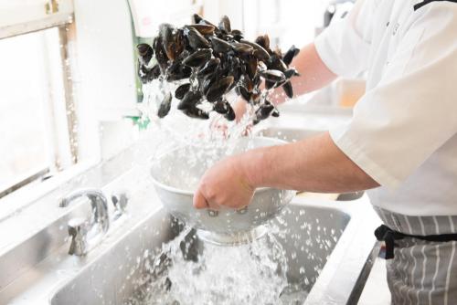 a chef is mixing ingredients in a bowl in a sink at The Glenmorangie House in Tain